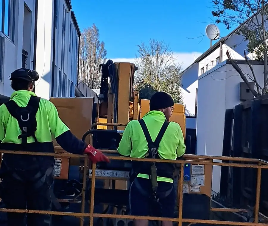 Two Mobi-Vac crew in an elevated work platform at a multi-unit Christchurch site